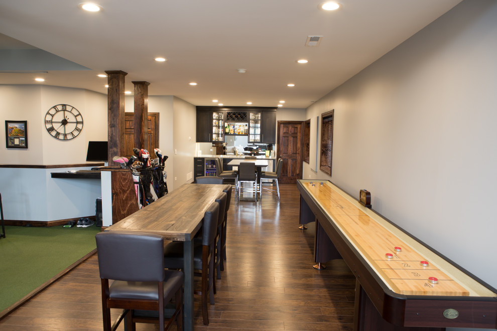 Example of a large transitional look-out laminate floor and brown floor basement design in Chicago with gray walls and no fireplace