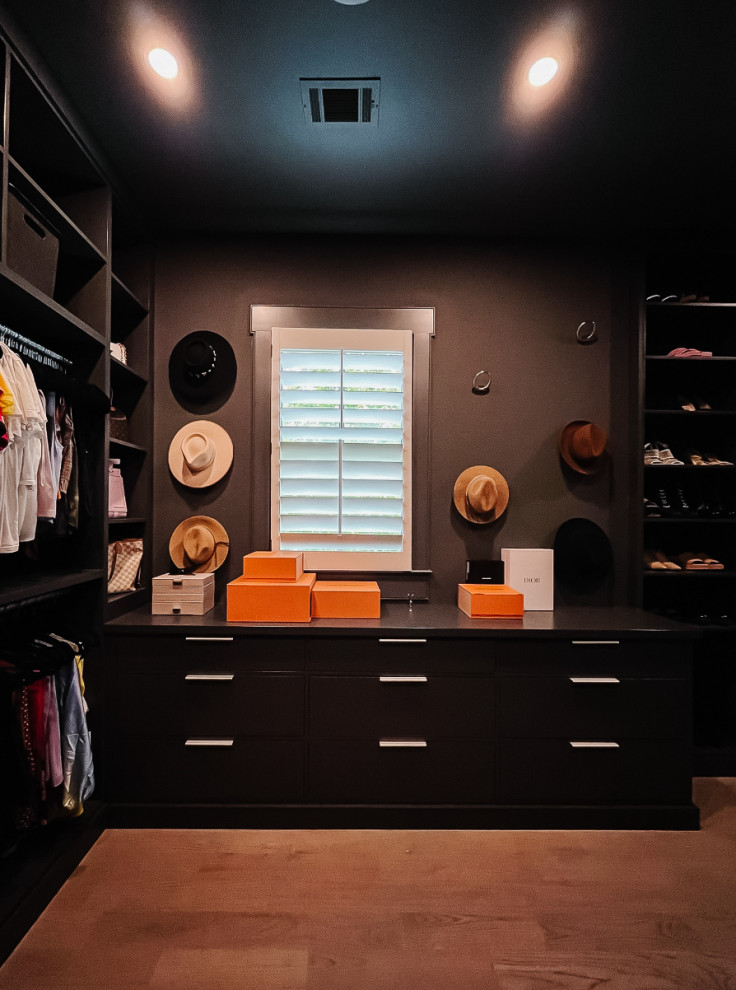 На фото: гардеробная комната унисекс с открытыми фасадами, черными фасадами и светлым паркетным полом