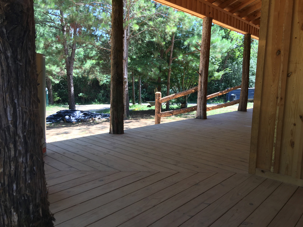 Large mountain style front porch idea with decking and a roof extension