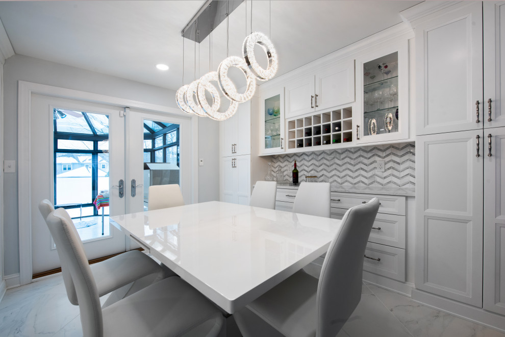 Large contemporary galley eat-in kitchen in Philadelphia with an undermount sink, shaker cabinets, white cabinets, quartz benchtops, white splashback, marble splashback, stainless steel appliances, porcelain floors, with island, white floor and white benchtop.