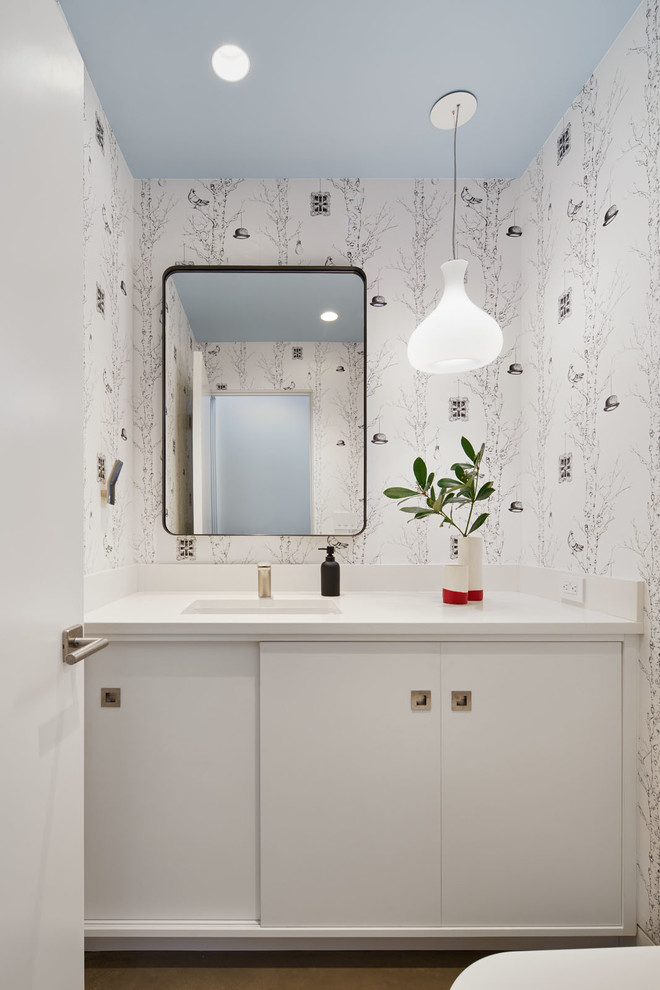 Contemporary powder room in San Francisco with flat-panel cabinets, white cabinets, multi-coloured walls and an undermount sink.