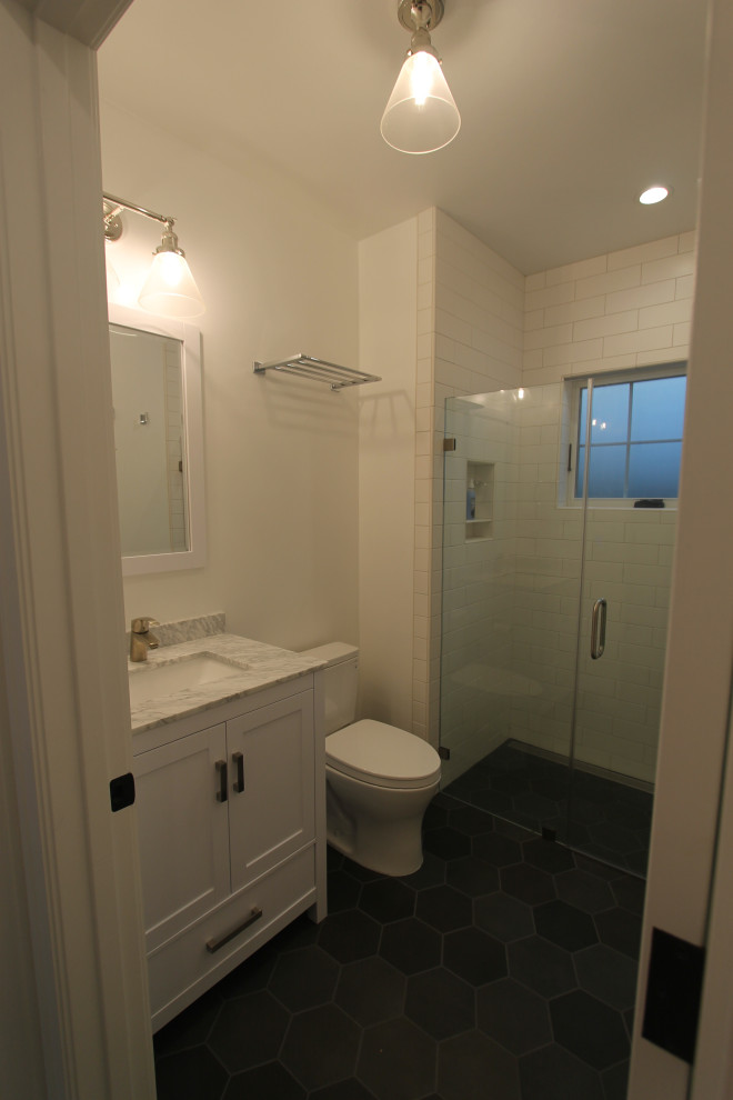 Пример оригинального дизайна: маленькая ванная комната в стиле неоклассика (современная классика) с фасадами с утопленной филенкой, белыми фасадами, душем без бортиков, раздельным унитазом, белой плиткой, керамической плиткой, белыми стенами, полом из керамогранита, врезной раковиной, мраморной столешницей, зеленым полом, душем с распашными дверями, серой столешницей, нишей, тумбой под одну раковину и напольной тумбой для на участке и в саду