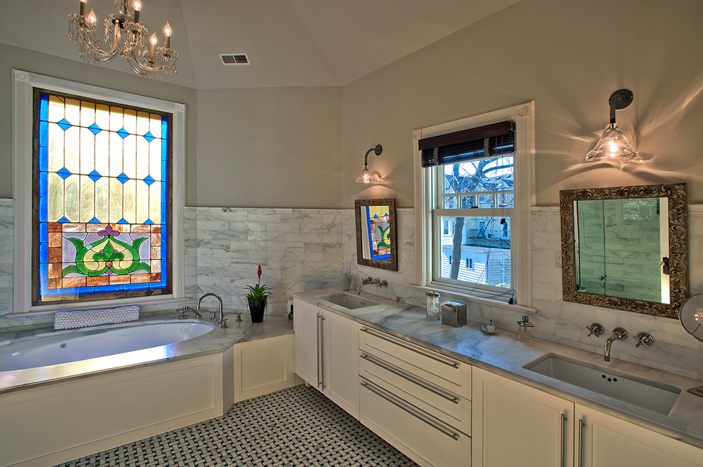 Large traditional master bathroom in New York with shaker cabinets, white cabinets, an undermount tub, gray tile, white tile, stone tile, beige walls, porcelain floors, an undermount sink, marble benchtops and multi-coloured floor.