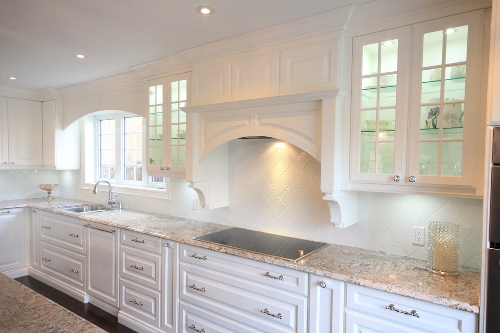 Mid-sized transitional galley dark wood floor eat-in kitchen photo in Toronto with raised-panel cabinets, white cabinets, quartzite countertops, white backsplash, stainless steel appliances and an island
