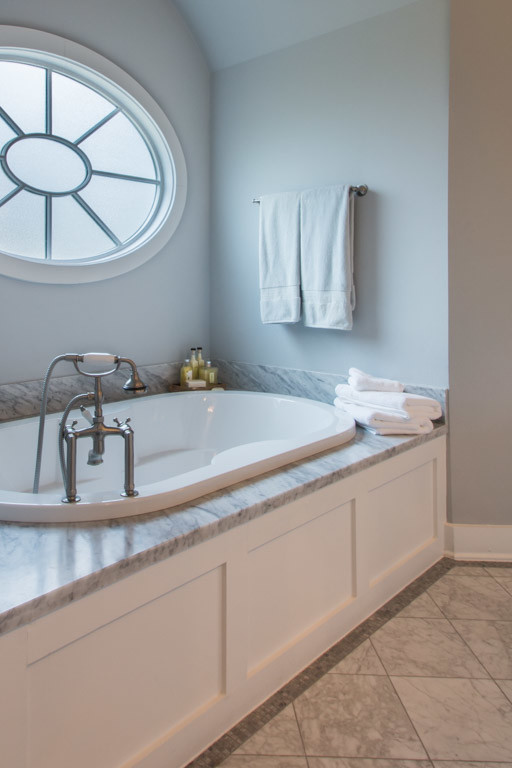 Photo of a large traditional master bathroom in Houston with shaker cabinets, white cabinets, marble benchtops, a drop-in tub, gray tile, stone tile, grey walls and marble floors.