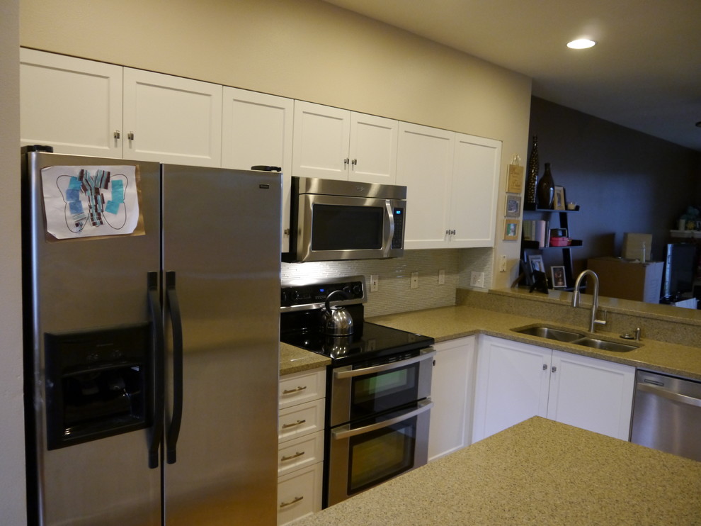 Inspiration for a transitional eat-in kitchen remodel in Seattle with an undermount sink, shaker cabinets, white cabinets, granite countertops, glass tile backsplash, stainless steel appliances and an island