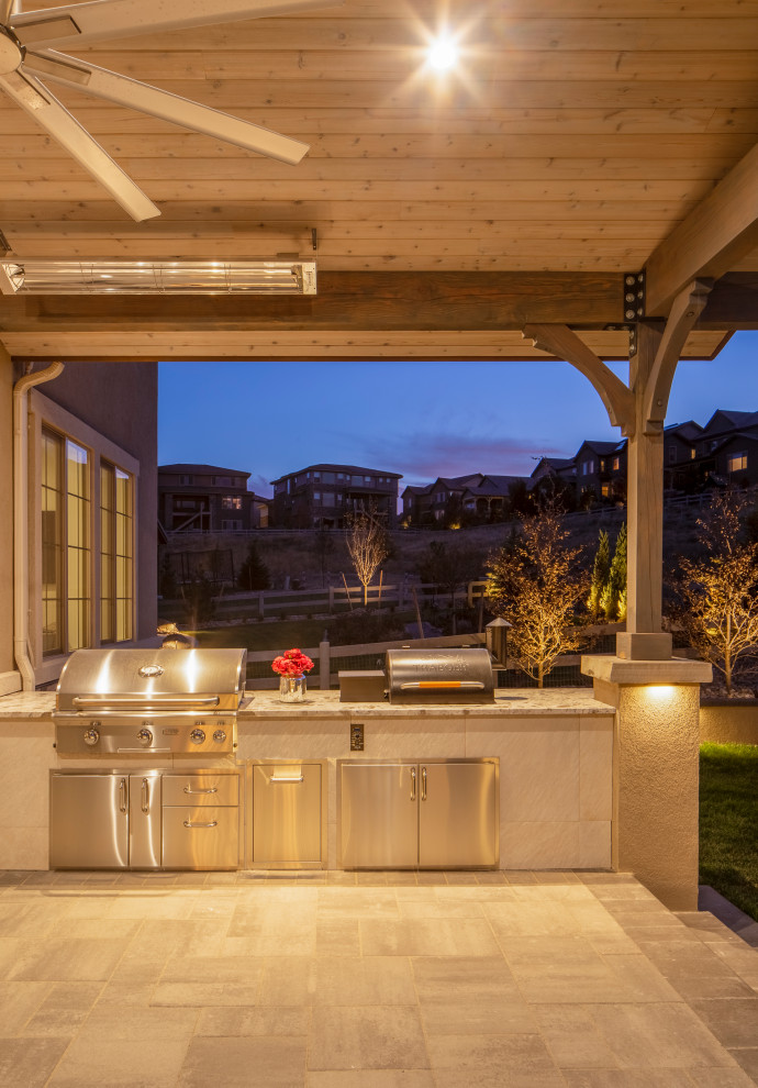 Inspiration for a large modern backyard patio in Denver with an outdoor kitchen, concrete pavers and a roof extension.