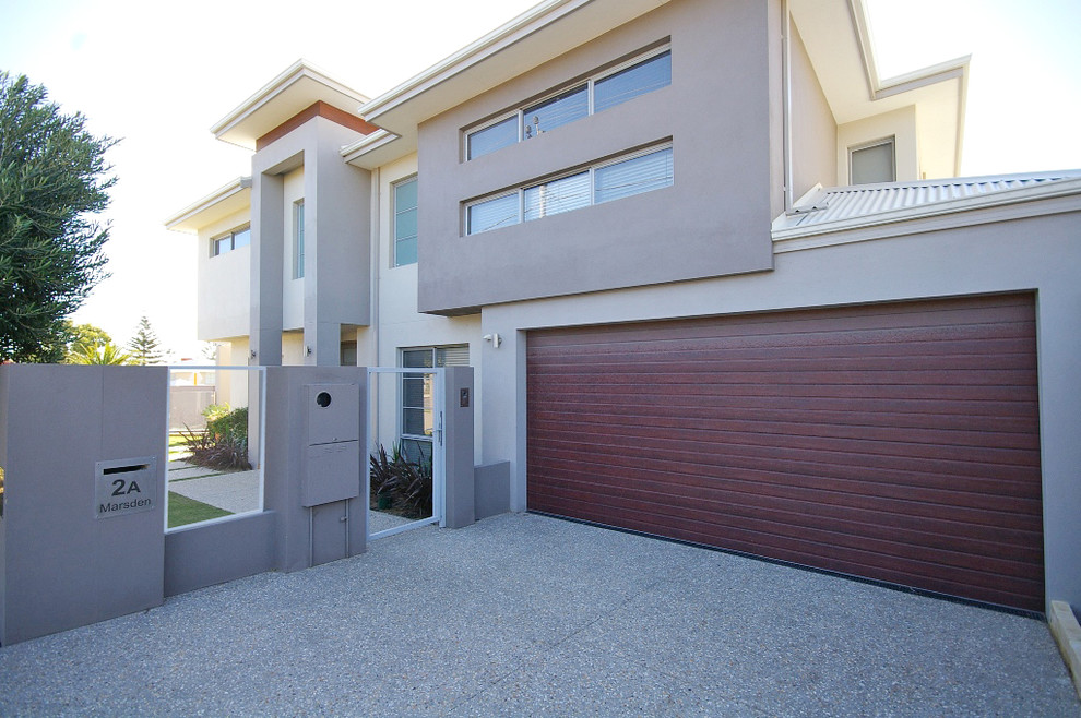 Photo of a mid-sized modern two-storey concrete grey house exterior in Perth with a hip roof and a metal roof.