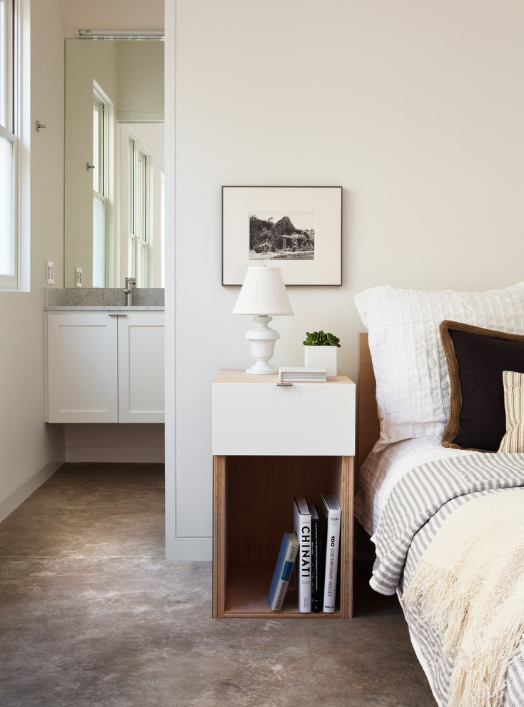 This is an example of a transitional bedroom in San Francisco with concrete floors.