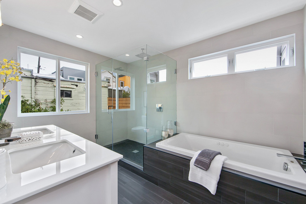 Mid-sized contemporary master bathroom in San Francisco with an undermount sink, shaker cabinets, white cabinets, marble benchtops, a drop-in tub, a double shower, a one-piece toilet, gray tile, porcelain tile, porcelain floors and beige walls.