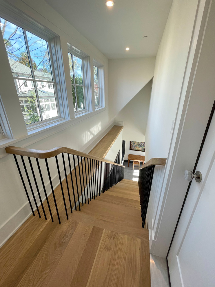 Diseño de escalera suspendida minimalista extra grande con escalones de madera, barandilla de varios materiales y machihembrado