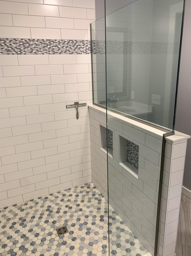 Идея дизайна: главная ванная комната среднего размера в морском стиле с фасадами с утопленной филенкой, синими фасадами, душем в нише, унитазом-моноблоком, белой плиткой, керамогранитной плиткой, серыми стенами, полом из керамической плитки, врезной раковиной, столешницей из искусственного кварца, серым полом, душем с распашными дверями, белой столешницей, тумбой под две раковины и встроенной тумбой