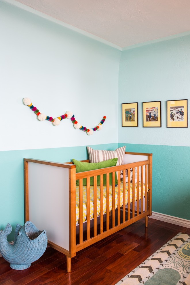 Inspiration for a mid-sized beach style nursery for boys in Los Angeles with blue walls and medium hardwood floors.
