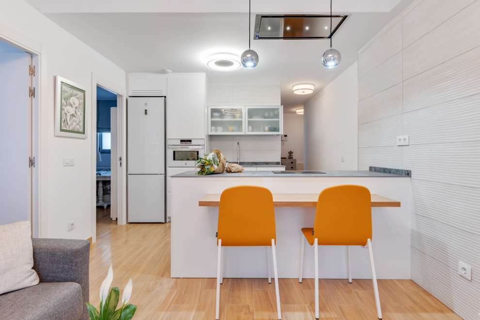 Moderne Küche mit Waschbecken, Granit-Arbeitsplatte und weißen Elektrogeräten in Sonstige