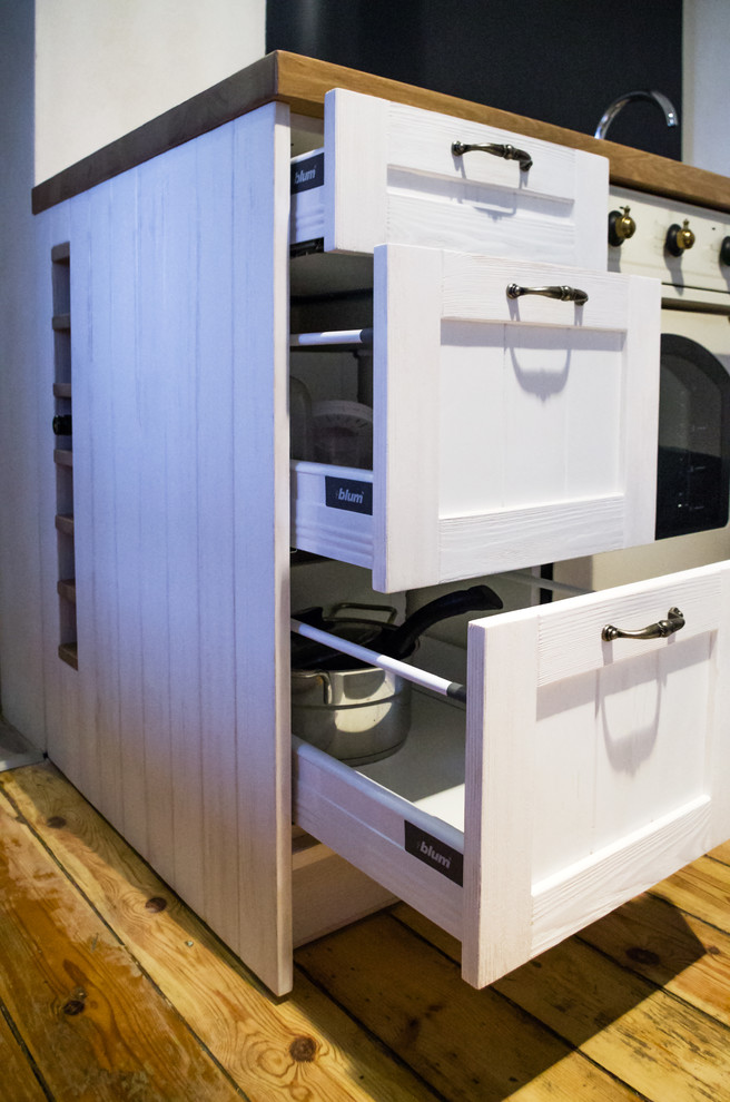 Example of a small mountain style single-wall kitchen design with recessed-panel cabinets