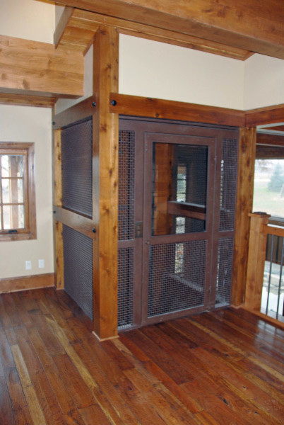 Example of a mid-sized mountain style medium tone wood floor single front door design in Orange County with beige walls and a brown front door