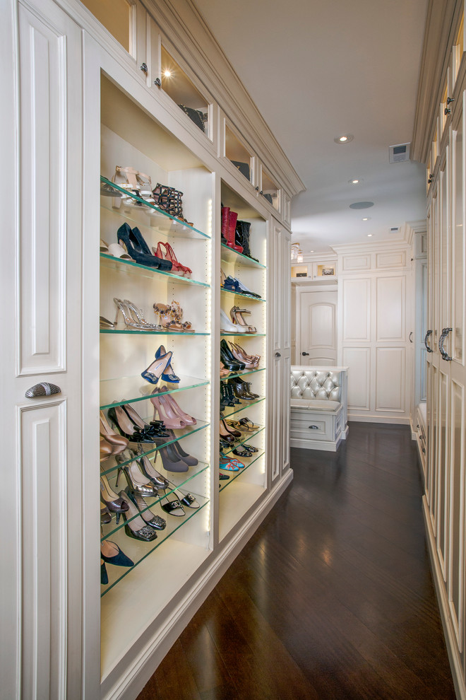 This is an example of a large traditional women's dressing room in Chicago with dark hardwood floors, recessed-panel cabinets and white cabinets.