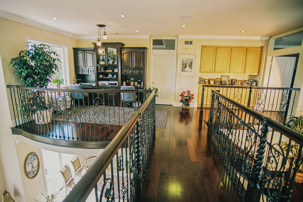 Mid-sized transitional built-in desk dark wood floor home design photo in Orange County with yellow walls