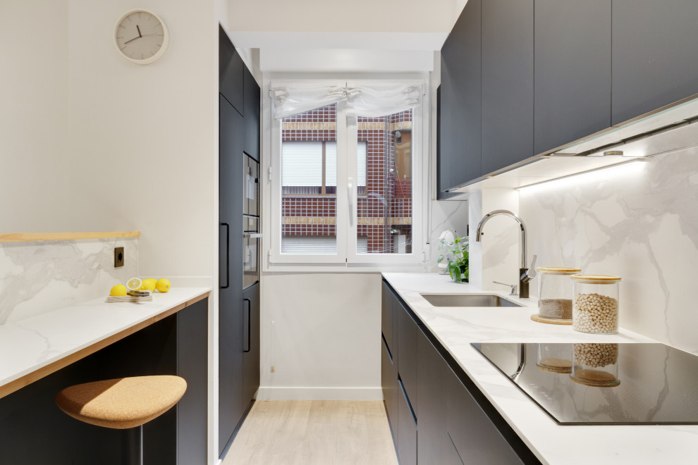 Inspiration for a contemporary galley kitchen in Other with an undermount sink, flat-panel cabinets, grey cabinets, white splashback, panelled appliances, light hardwood floors, no island, beige floor and white benchtop.