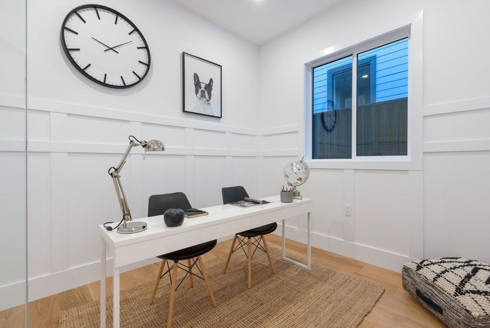 Idee per un ufficio minimal di medie dimensioni con pareti bianche, parquet chiaro, pavimento beige e pannellatura