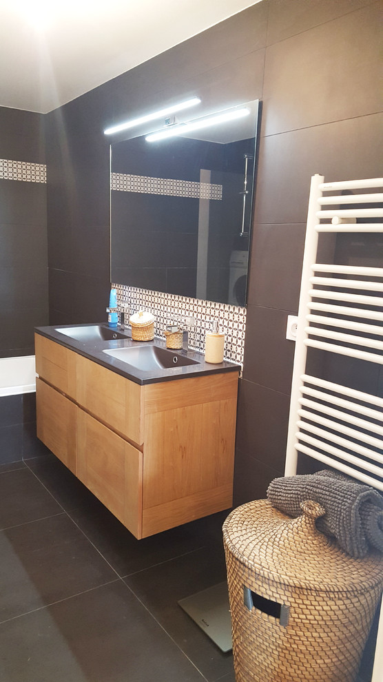 This is an example of a mid-sized scandinavian master wet room bathroom in Lyon with beaded inset cabinets, brown cabinets, a corner tub, brown tile, cement tile, brown walls, cement tiles, an integrated sink, tile benchtops, black floor and a hinged shower door.