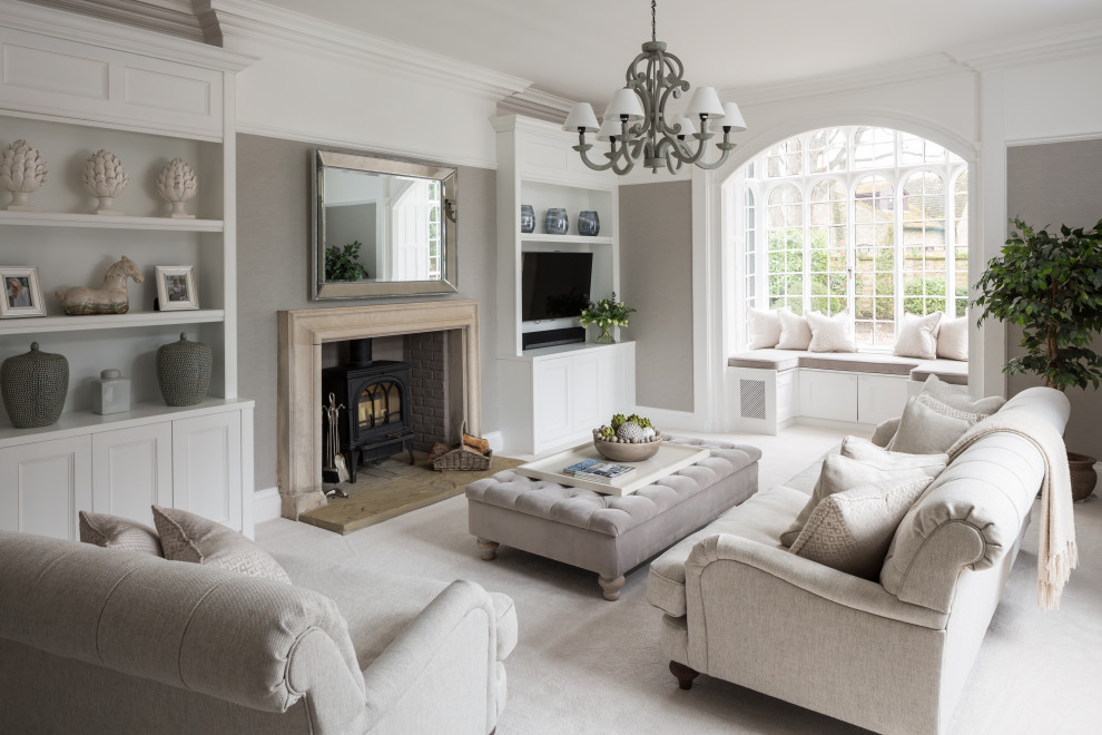 Offenes Klassisches Wohnzimmer mit grauer Wandfarbe, Teppichboden, Kamin, TV-Wand, weißem Boden und Wandpaneelen in Sonstige