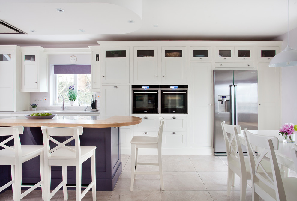 Design ideas for a transitional galley eat-in kitchen in Dublin with shaker cabinets, white cabinets, stainless steel appliances and with island.