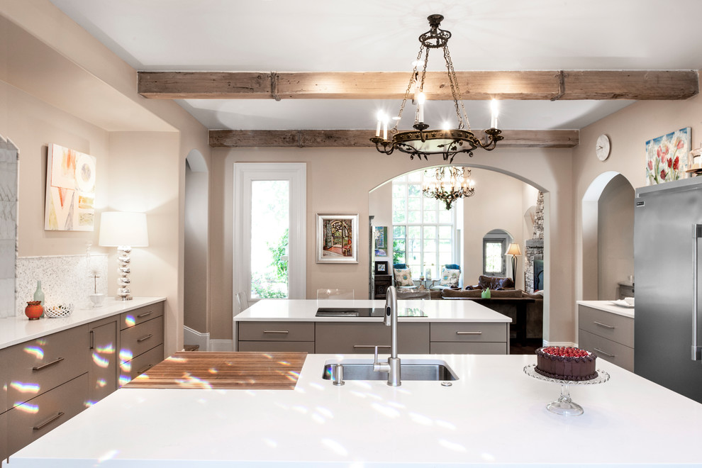Inspiration for a mid-sized transitional ceramic tile and brown floor enclosed kitchen remodel with an undermount sink, flat-panel cabinets, beige cabinets, quartzite countertops, white backsplash, ceramic backsplash, stainless steel appliances, two islands and white countertops