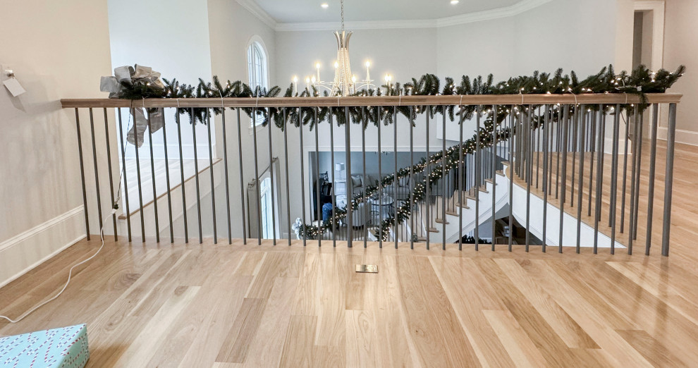 Photo of a large traditional wood floating staircase in DC Metro with painted wood risers and mixed railing.