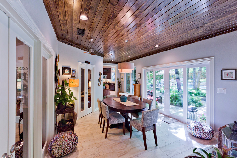 Photo of a large tropical separate dining room in Dallas with grey walls, porcelain floors, no fireplace and beige floor.