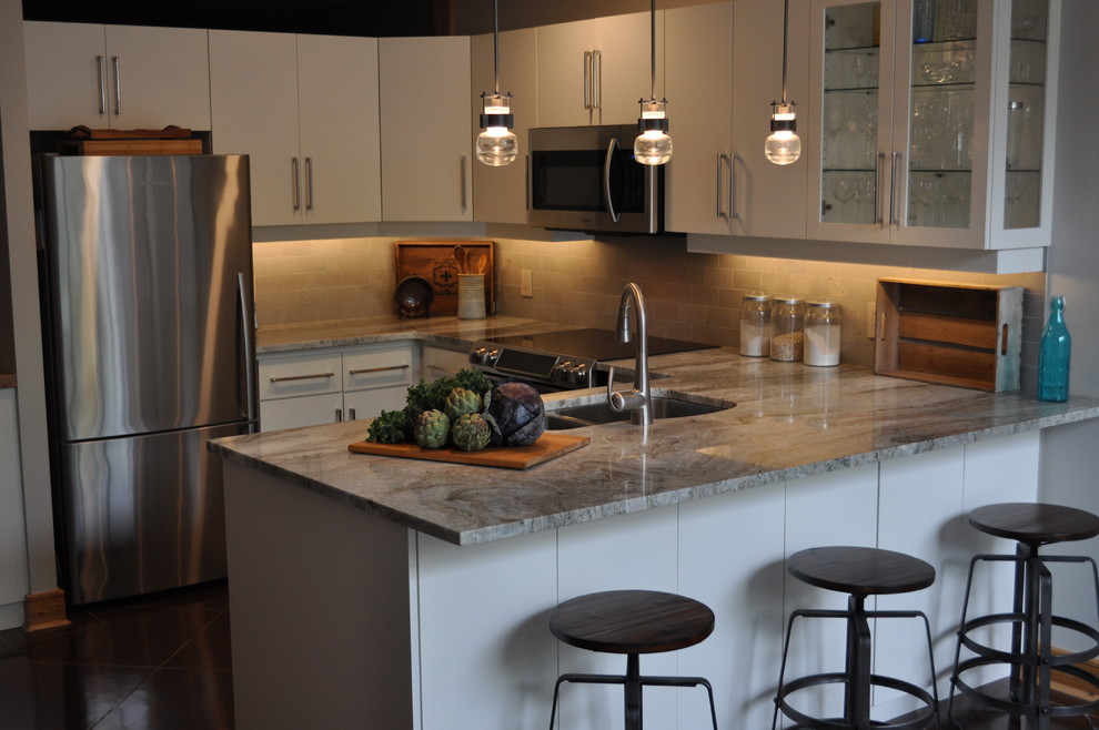 Inspiration for a small transitional u-shaped open concept kitchen remodel in Toronto with a double-bowl sink, flat-panel cabinets, white cabinets, marble countertops, beige backsplash, stone tile backsplash and stainless steel appliances