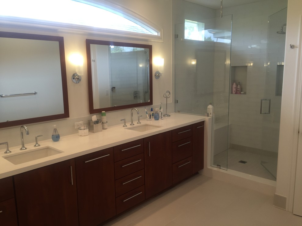 This is an example of a large master bathroom in San Francisco with flat-panel cabinets, brown cabinets, a freestanding tub, a curbless shower, a two-piece toilet, white tile, subway tile, white walls, ceramic floors, an integrated sink and engineered quartz benchtops.