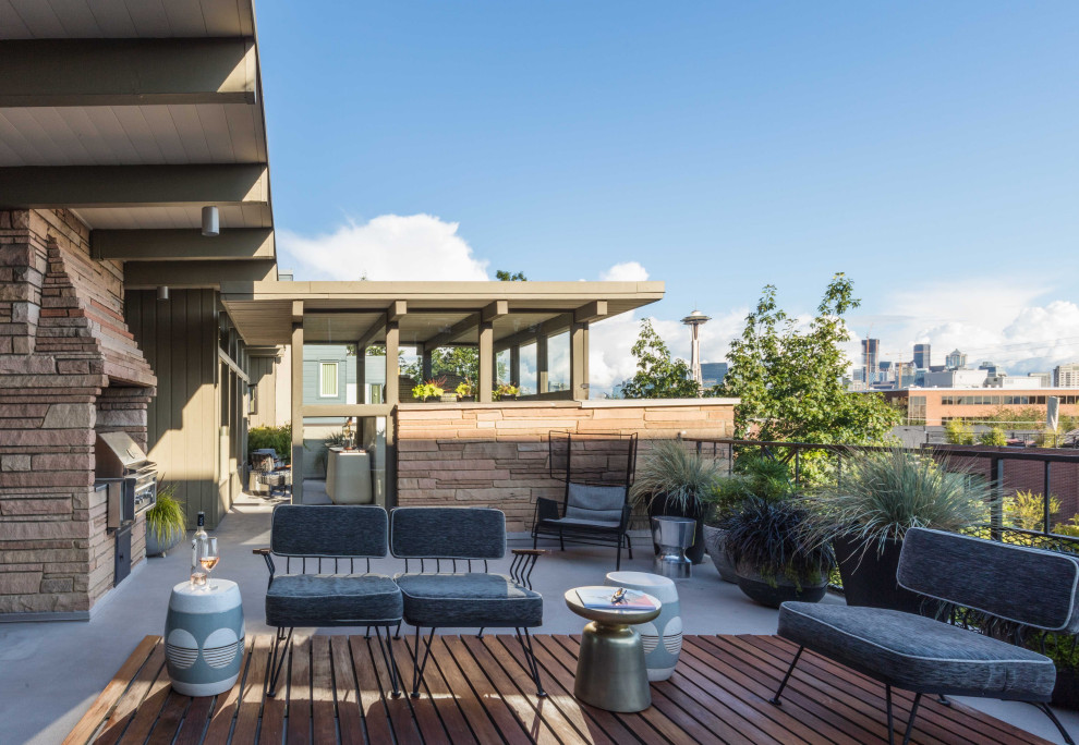 Inspiration for a midcentury rooftop deck in Seattle with a container garden and a roof extension.