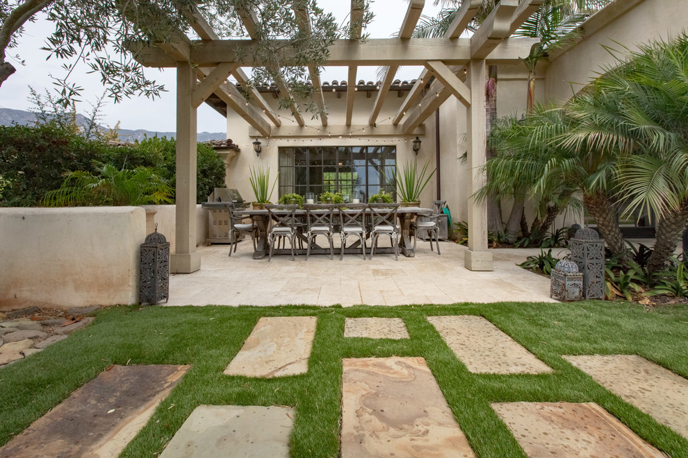 Design ideas for a mediterranean courtyard patio in Santa Barbara with natural stone pavers and a pergola.
