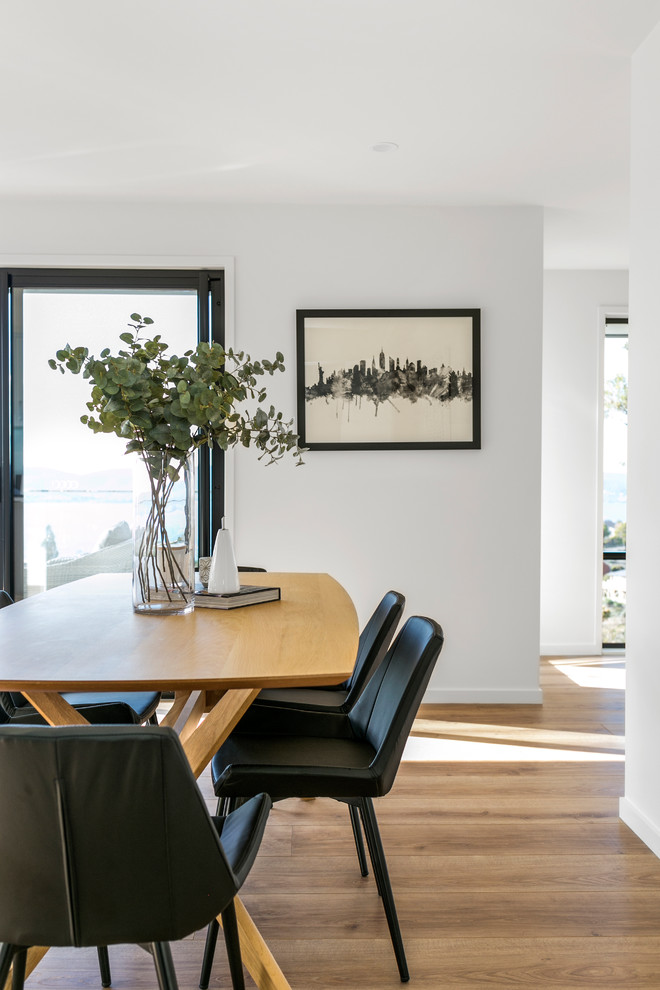 Design ideas for a contemporary open plan dining in Hobart with white walls and light hardwood floors.