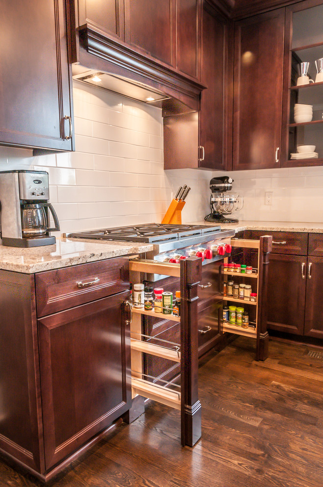 Inspiration for a mid-sized transitional u-shaped dark wood floor eat-in kitchen remodel in Chicago with a farmhouse sink, recessed-panel cabinets, dark wood cabinets, granite countertops, white backsplash, ceramic backsplash, stainless steel appliances and an island