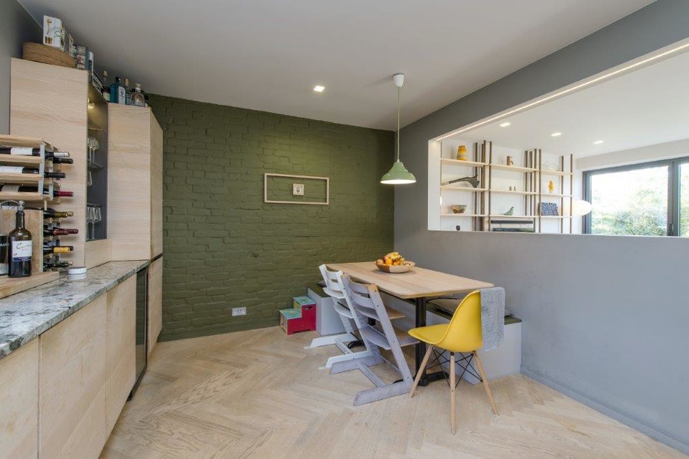 Inspiration for a mid-sized modern l-shaped eat-in kitchen in London with a drop-in sink, flat-panel cabinets, light wood cabinets, quartzite benchtops, green splashback, brick splashback, stainless steel appliances, light hardwood floors, beige floor and green benchtop.