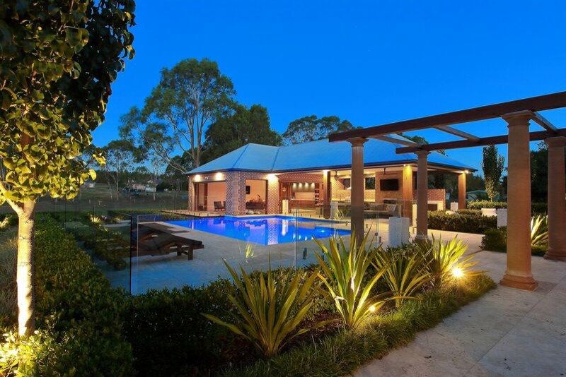 Photo of an expansive contemporary backyard rectangular lap pool in Sydney with a pool house and decking.