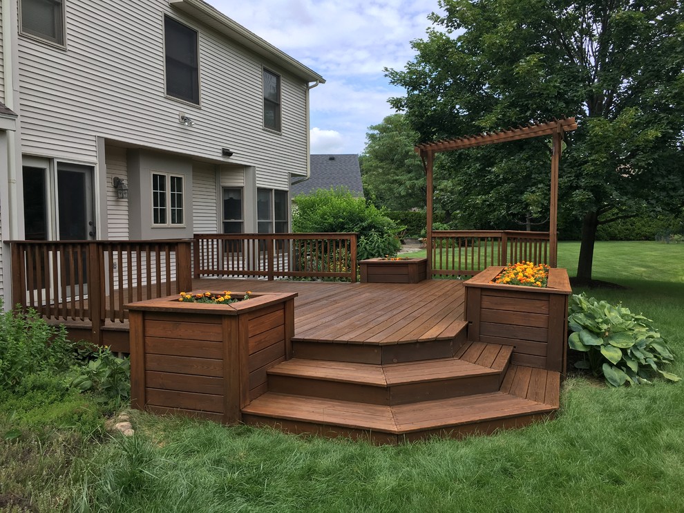 This is an example of a mid-sized transitional backyard deck in New York with a container garden and no cover.