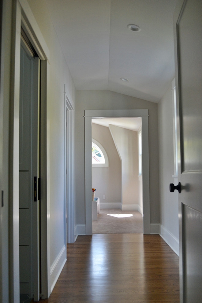 Inspiration for a mid-sized transitional hallway in St Louis with grey walls, medium hardwood floors and brown floor.