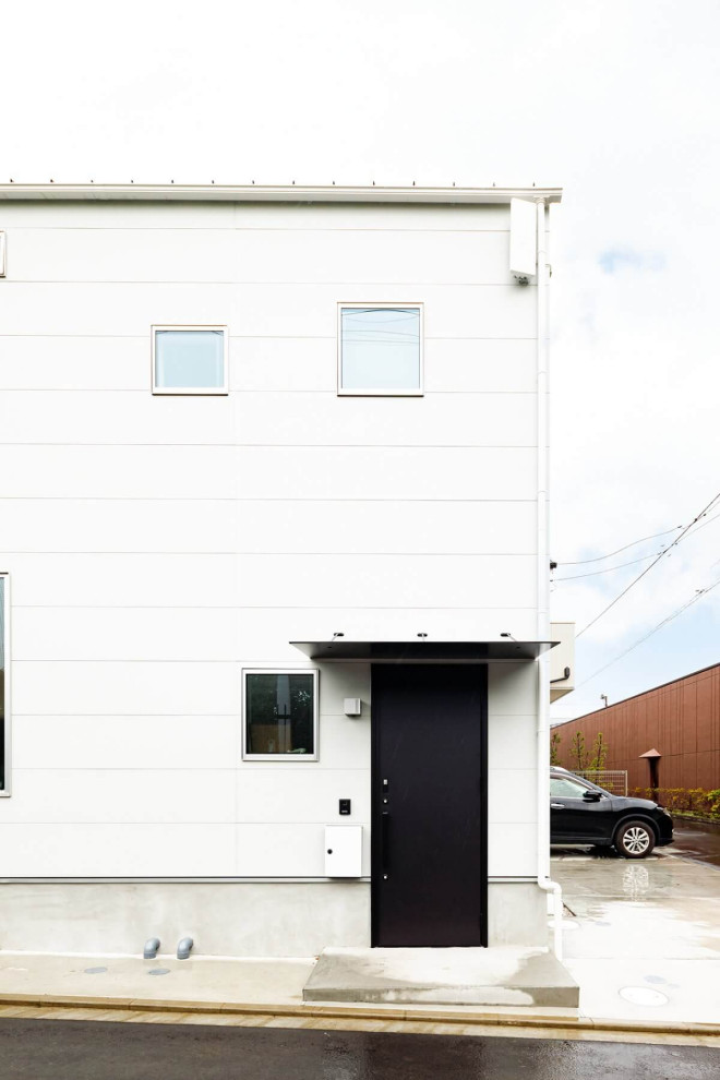 Esempio di una porta d'ingresso industriale di medie dimensioni con una porta singola, una porta nera, soffitto in carta da parati e carta da parati