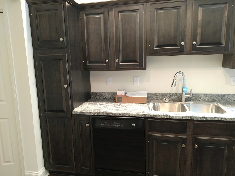 Mid-sized transitional u-shaped laminate floor and multicolored floor home design photo with a drop-in sink, raised-panel cabinets, dark wood cabinets, laminate countertops, multicolored backsplash, black appliances, a peninsula and multicolored countertops