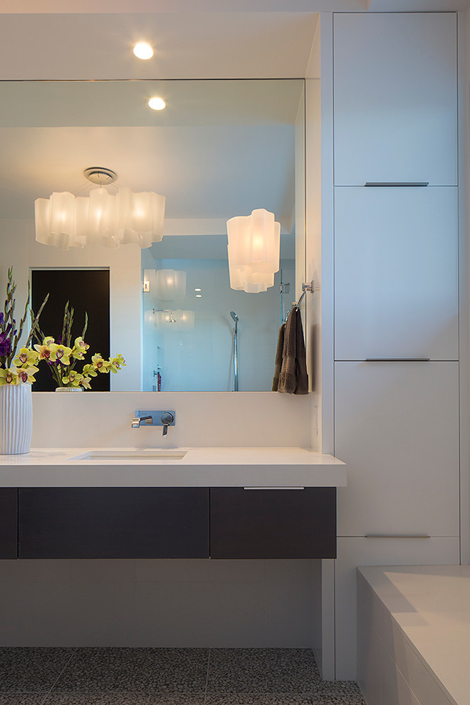 Photo of a large contemporary master bathroom in San Francisco with flat-panel cabinets, white cabinets, solid surface benchtops, an undermount sink, a drop-in tub, white tile, ceramic tile, white walls and mosaic tile floors.