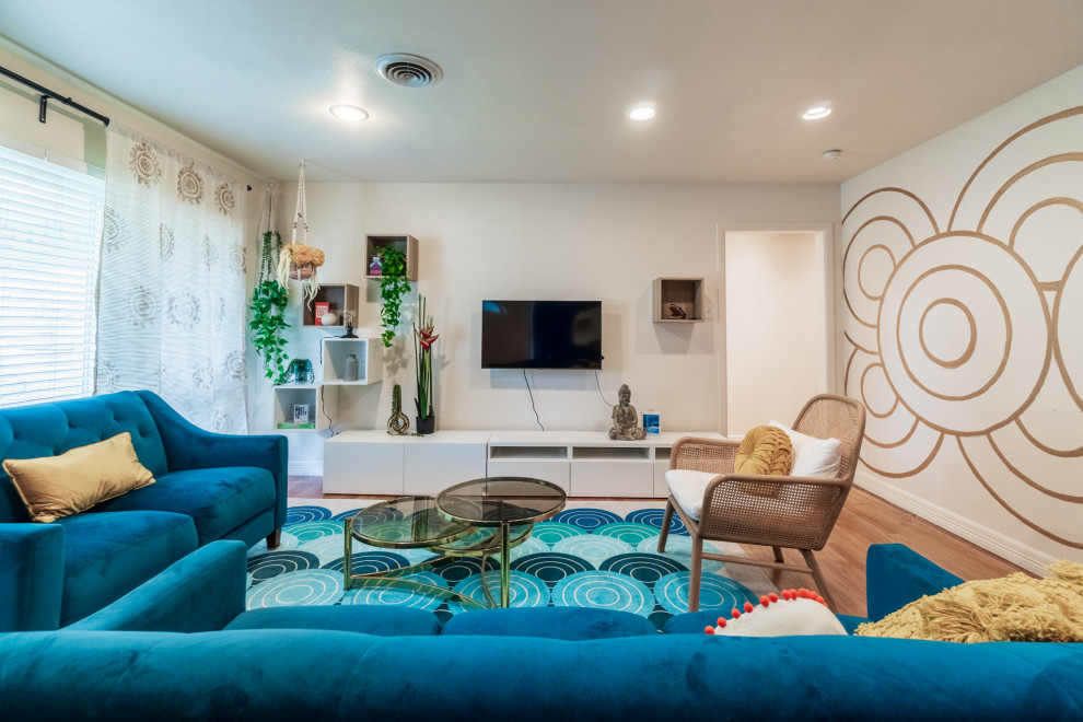 Photo of a mid-sized eclectic open concept living room in Dallas with multi-coloured walls, medium hardwood floors, a wall-mounted tv and brown floor.