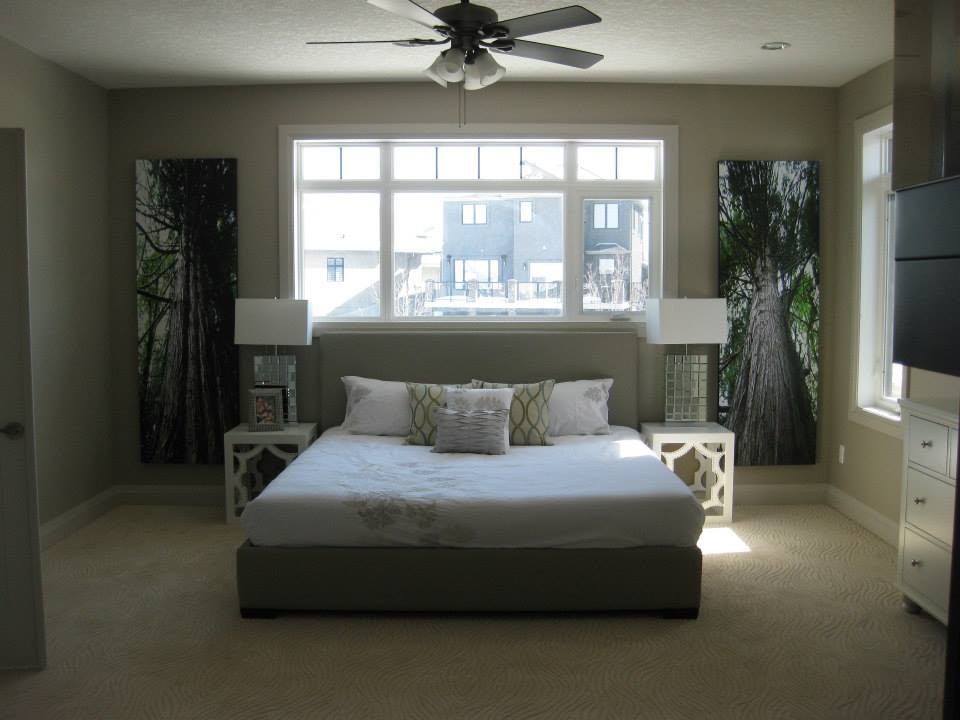 This is an example of a mid-sized transitional guest bedroom in Calgary with beige walls and carpet.