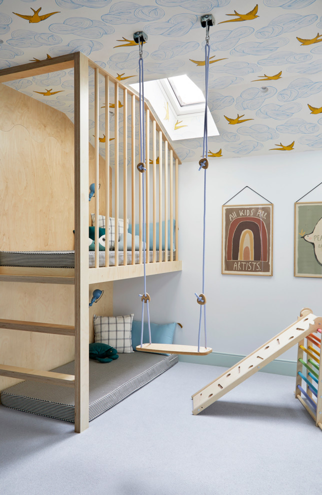 Foto på ett stort skandinaviskt könsneutralt barnrum kombinerat med lekrum, med blå väggar, heltäckningsmatta och blått golv