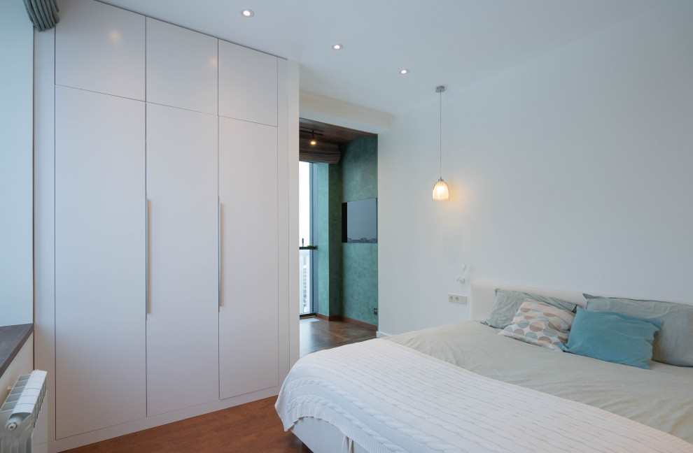На фото: большая хозяйская спальня в белых тонах с отделкой деревом в современном стиле с белыми стенами, пробковым полом, коричневым полом, сводчатым потолком и панелями на части стены