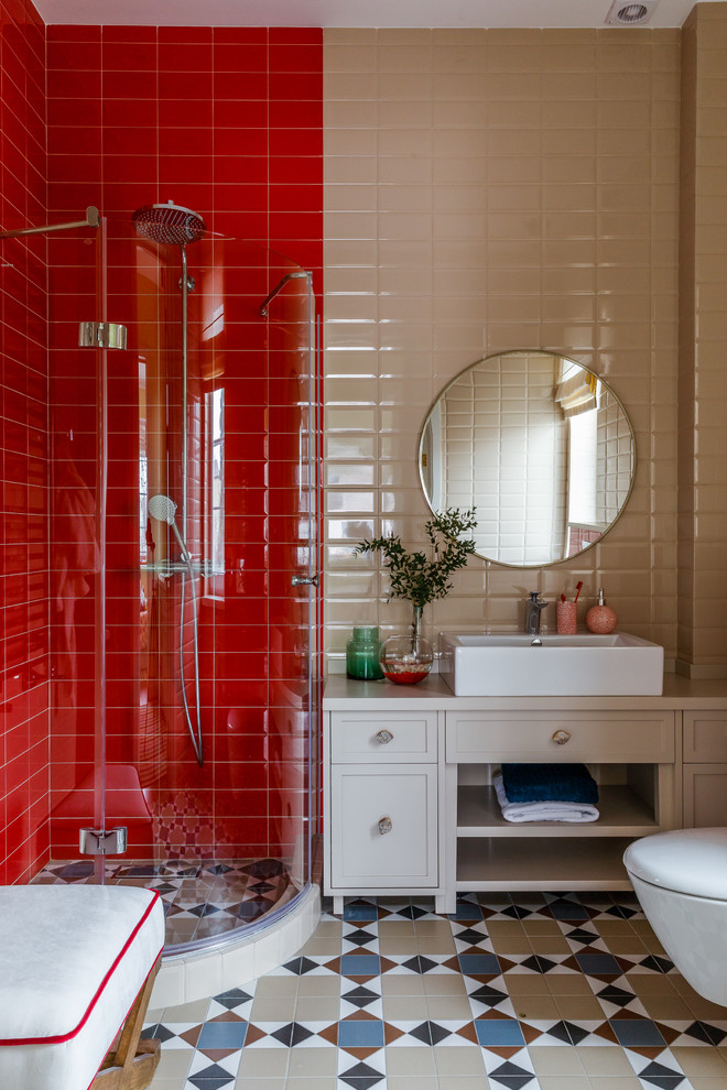 Photo of a contemporary 3/4 bathroom in Other with recessed-panel cabinets, white cabinets, a corner shower, a wall-mount toilet, beige tile, red tile, a vessel sink, multi-coloured floor and beige benchtops.