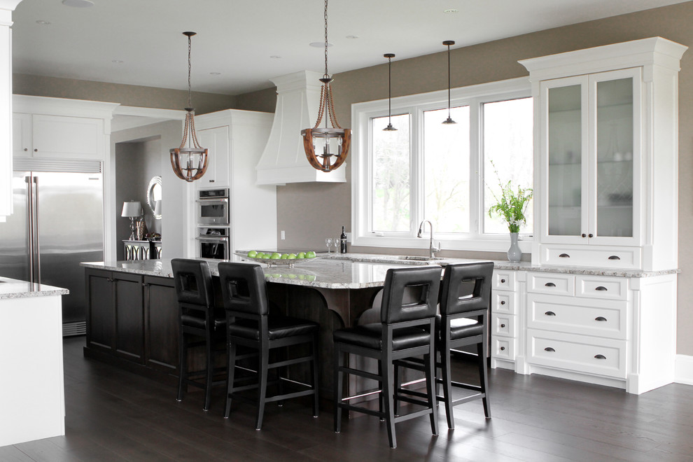 Mid-sized transitional l-shaped light wood floor open concept kitchen photo in Toronto with a double-bowl sink, shaker cabinets, white cabinets, granite countertops, stainless steel appliances and an island