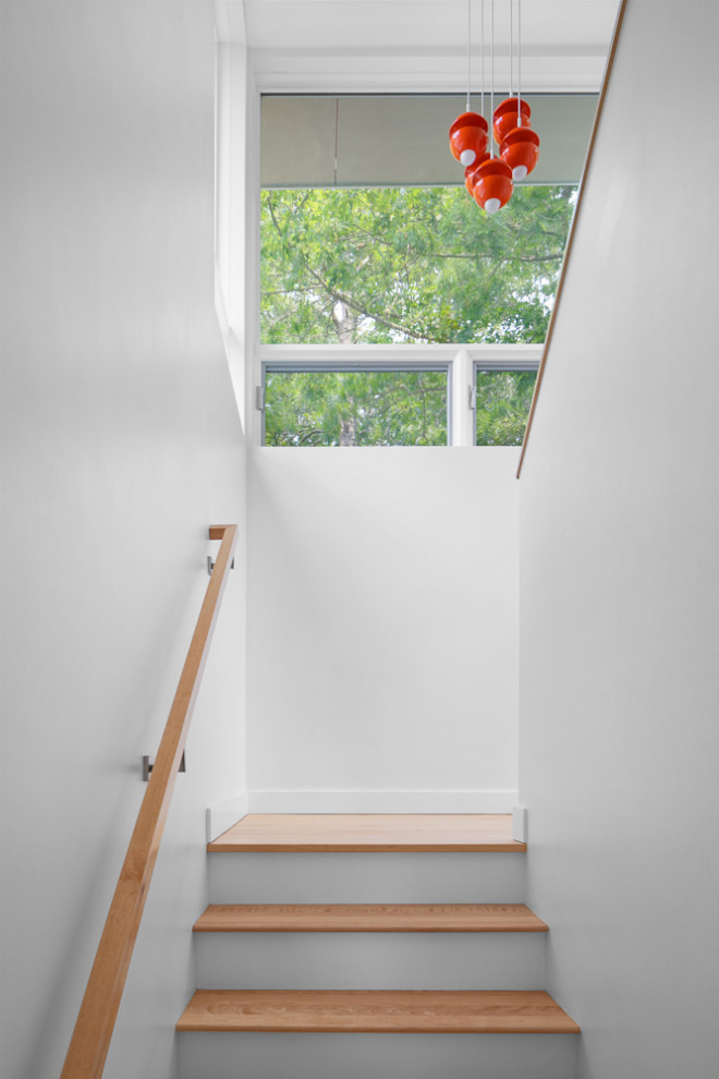 Esempio di una scala a "U" minimalista di medie dimensioni con pedata in legno, alzata in legno verniciato e parapetto in legno
